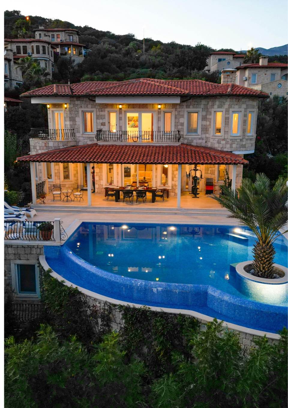 Villa contemporaine avec piscine à débordement au crépuscule